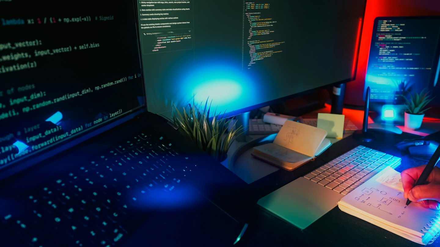 Bir programcı masasında defterine teknik diyagramlar çiziyor.